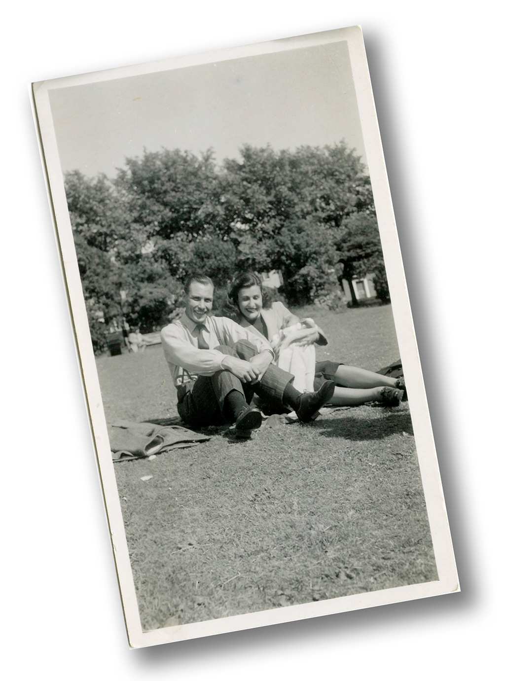 My parents with me as a baby, sitting on the grass, 1949